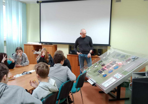 Mężczyzna opowiada młodzieży siedzącej przy stole