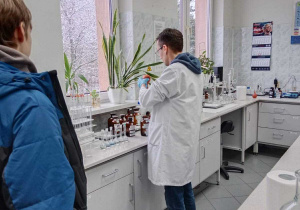 Mężczyzna w białym fartuchu pokazuje próbki materiałów