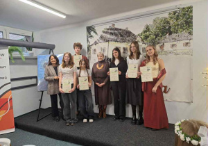 Grupa młodzieży z dwiema kobietami stoją na scenie