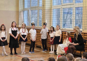 Uśmiechnięte dziewczynki w stroju galowymi chłopcy w czapkach górnika