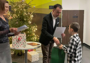 Mężczyzna wręcza nagrodę chłopcu