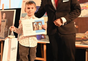 Mężczyzna obok chłopca z dyplomem