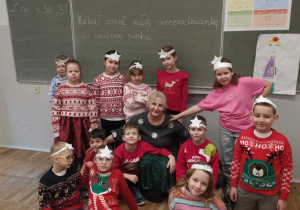 Radosne dzieci z kobietą ubrane w świąteczne swetry