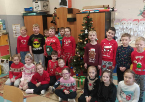 Uśmiechnięte dzieci ubrane w świąteczne swetry