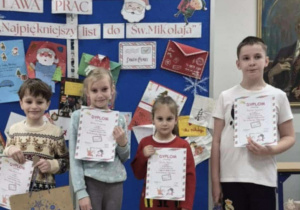 Uśmiechnięte dzieci trzymają nagrody i dyplomy