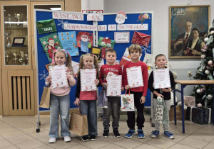 Uśmiechnięte dzieci trzymają nagrody i dyplomy