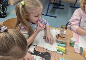 Dziewczynki dekorują lukrem pierniki