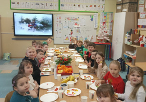 Radosne dzieci siedzą przy stole