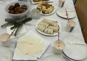 Stół z jedzeniem, nakryty białym obrusem