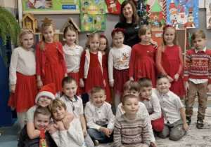 Uśmiechnięte dzieci z Panią pozują do zdjęcia grupowego