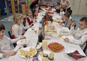 Dzieci siedzą przy świątecznym stole