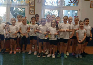 Uśmiechnięte dzieci trzymają łańcuch z dłoni