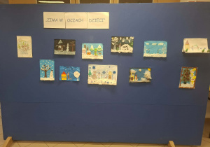 Tablica o tle granatowym z rysunkami o tematyce zimowej