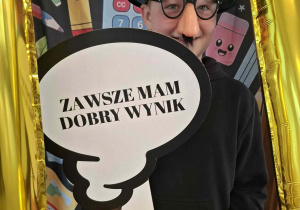 Dziecko w czarnym kapeluszu pozuje do zdjęcia w ramce