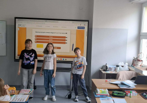 Radosne dzieci przed tablicą z kolorowym wykresem