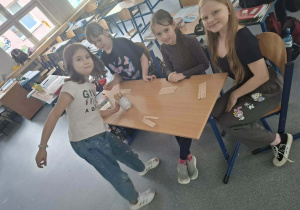 Uśmiechnięte dziewczynki układają patyczki na stoliku