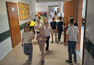 Dzieci z uśmiechem biegną przez korytarz