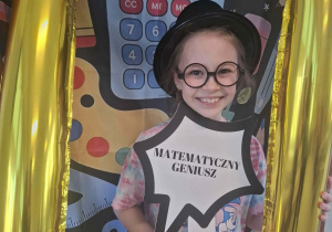 Dziecko w czarnym kapeluszu pozuje do zdjęcia w ramce