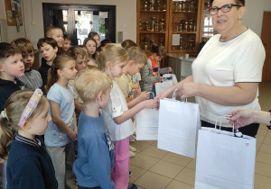 Uśmiechnięte dzieci otrzymują prezenty od kobiety