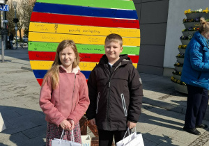 Dzieci stoją przed kolorowym jajkiem-pisanką