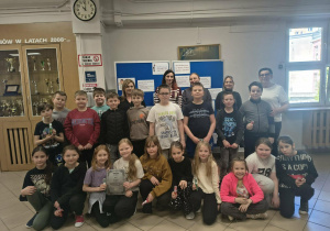 Grupa radosnych uczniów i pięć kobiet razem pozują do zdjęcia