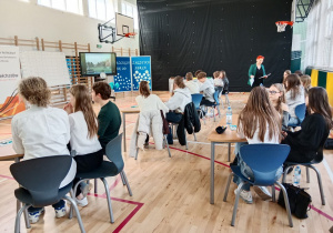 Uczniowie siedzą przy stolikach