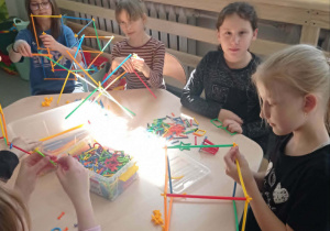 Uśmiechnięte dzieci układają patyki