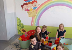 Uśmiechnięte dzieci na tle kolorowej fototapety na ścianie