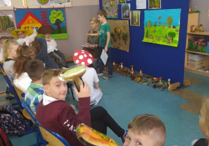 Dzieci na spotkaniu z panią leśnik z grzybami w ręku