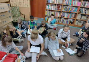 Dzieci siedzące na podłodze z książkami